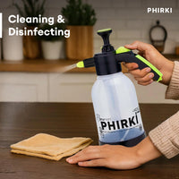 Person using a PHIRKI cleaning spray bottle on a table with a cloth.